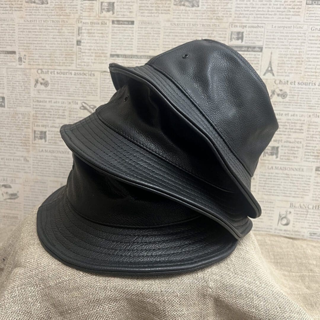 A black hat is sitting on top of another black hat.