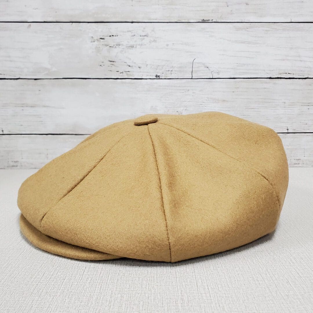 A tan hat sitting on top of a wooden table.