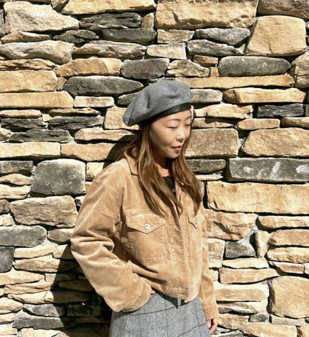 Woman in gray beret and corduroy jacket.