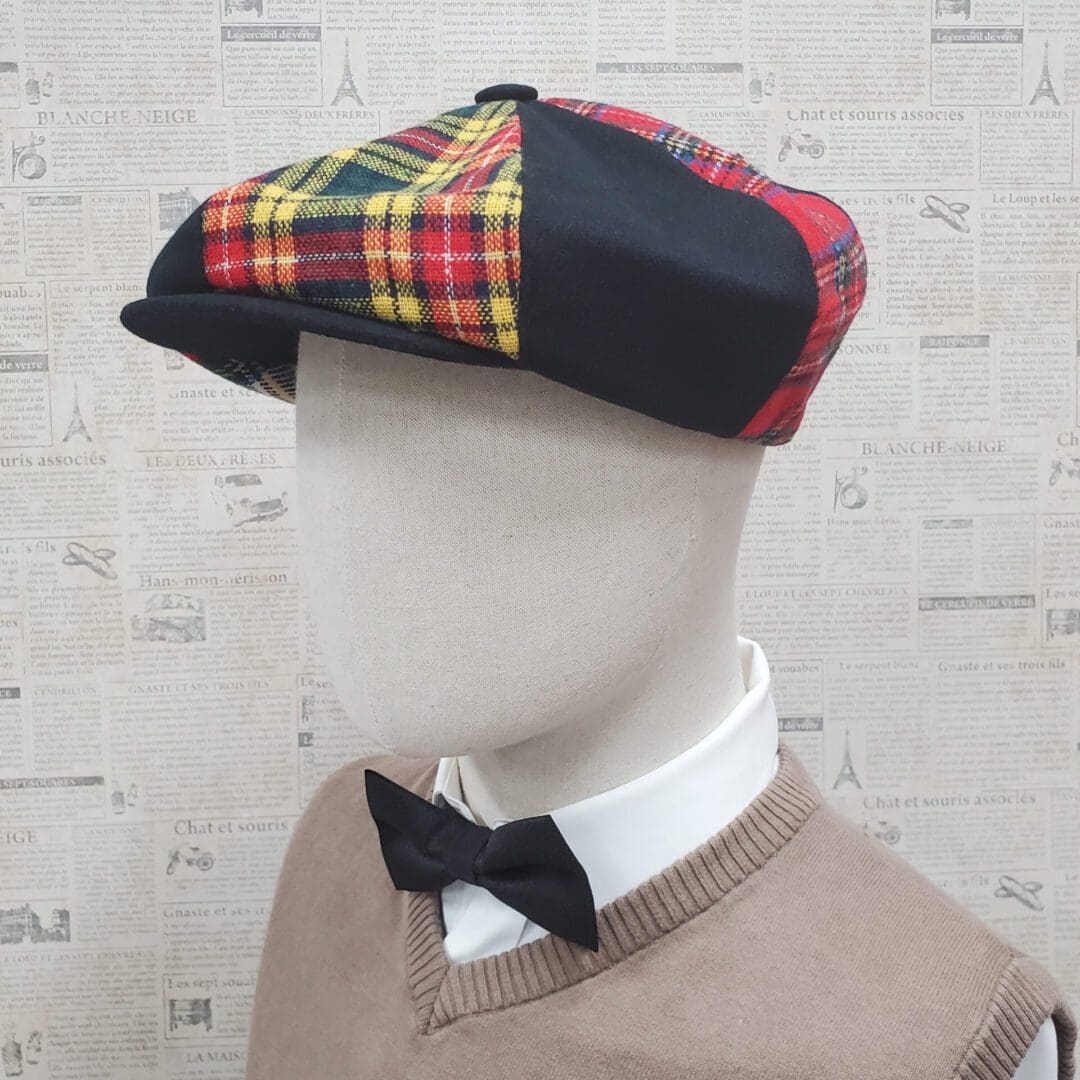 A man wearing a bow tie and plaid hat.