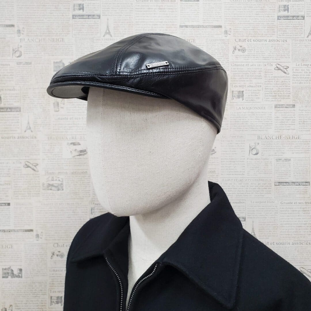 A man wearing a black leather hat and jacket.