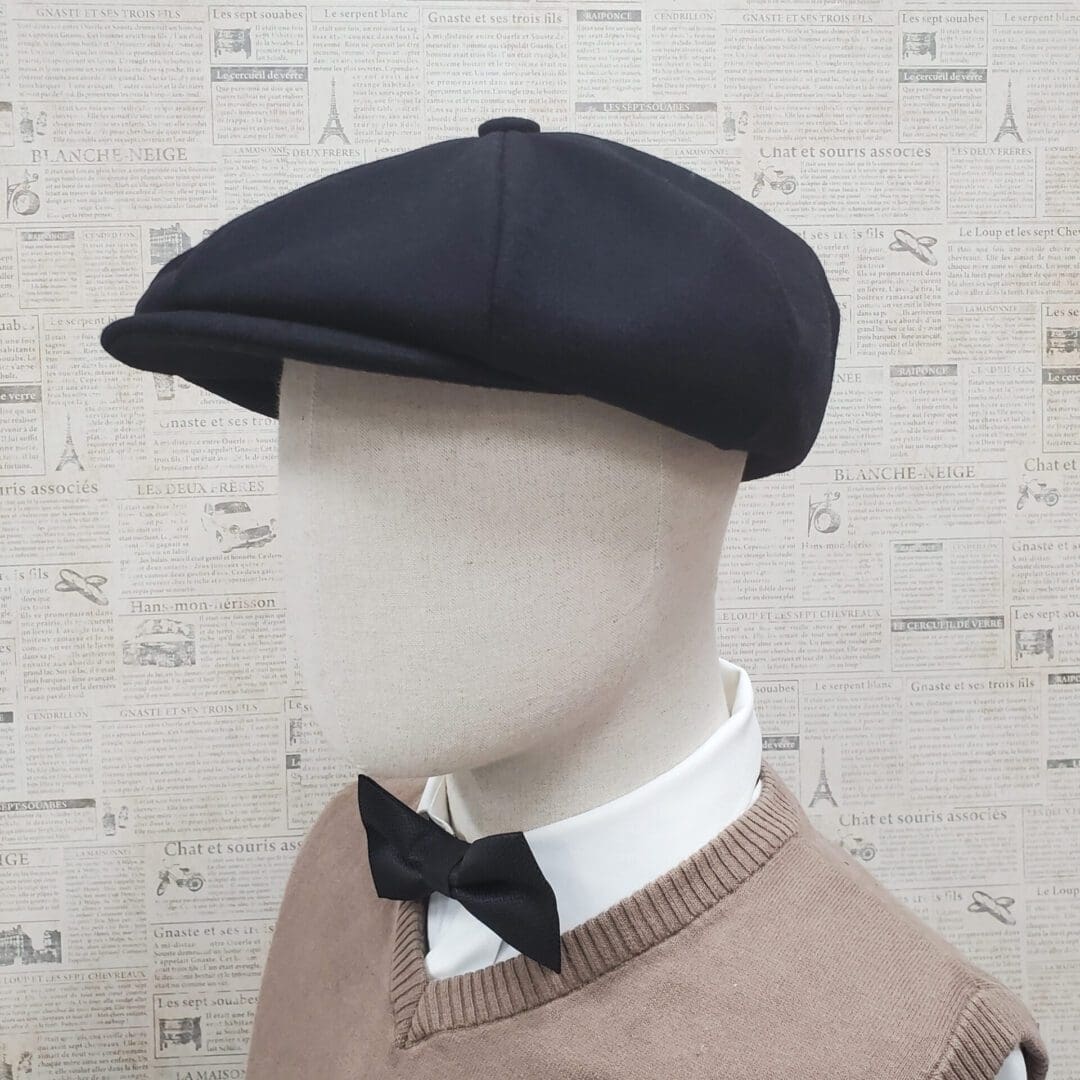 A mannequin wearing a black hat and bow tie.