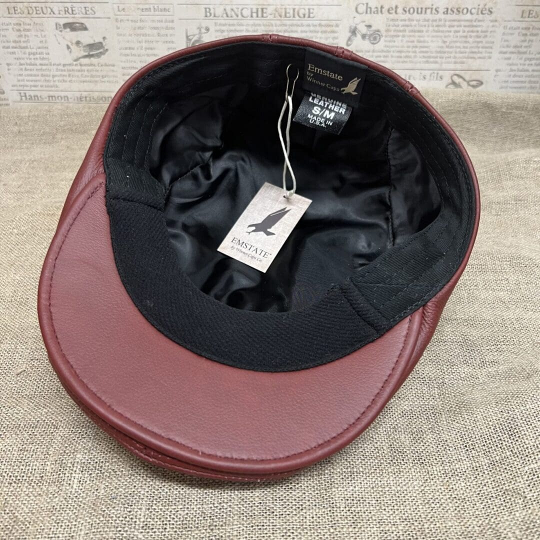 A red hat with a black cap on top of it.