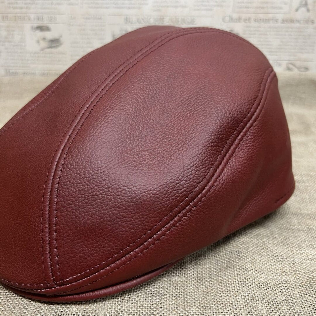 A brown leather cap sitting on top of a table.