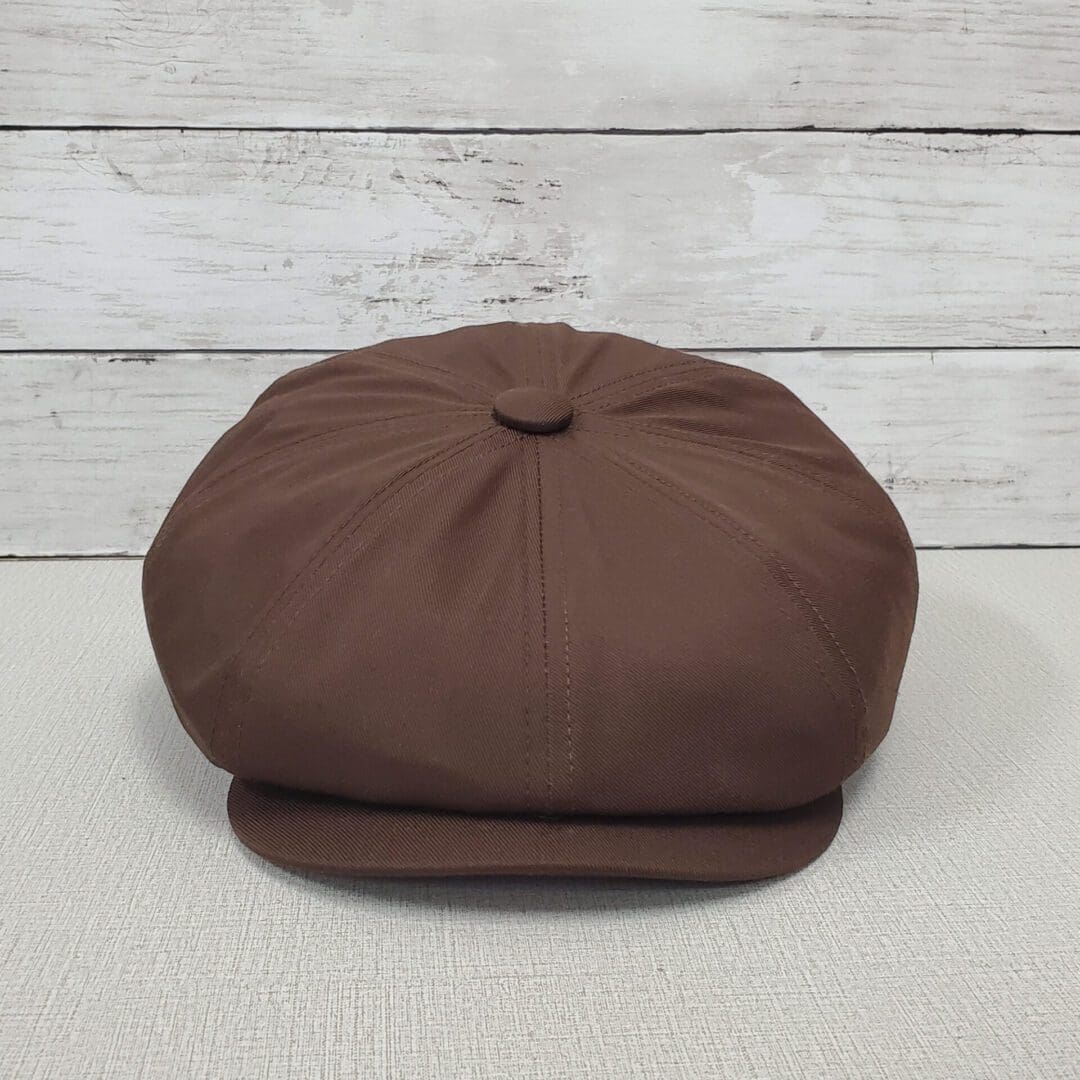 A brown hat sitting on top of a wooden table.