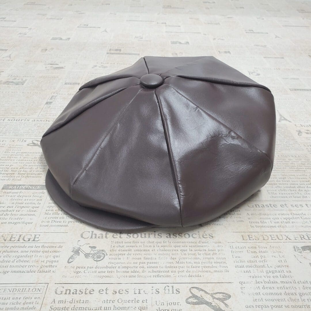 A brown leather hat sitting on top of a floor.
