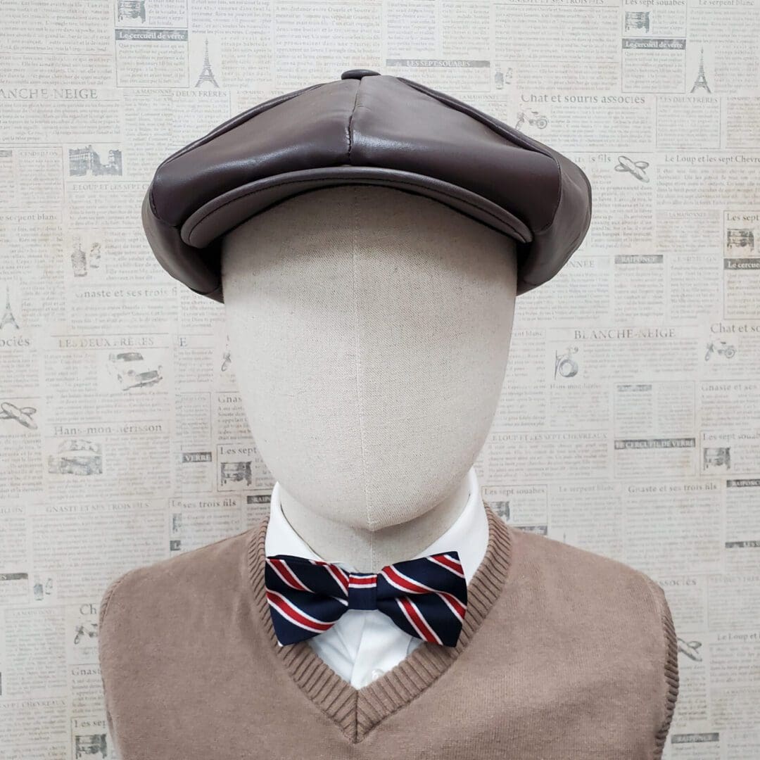 A mannequin wearing a hat and bow tie.