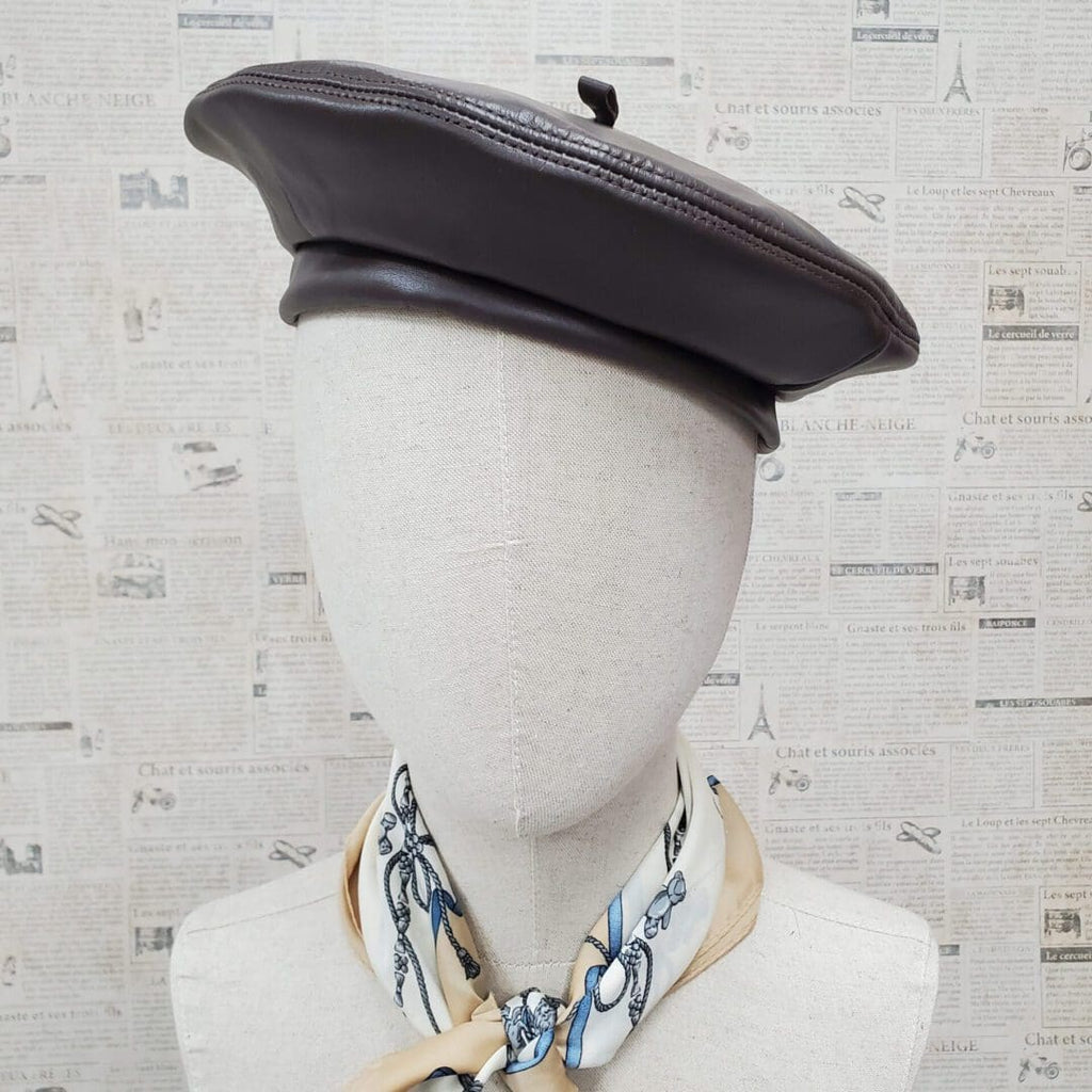 A mannequin wearing a black hat and scarf.