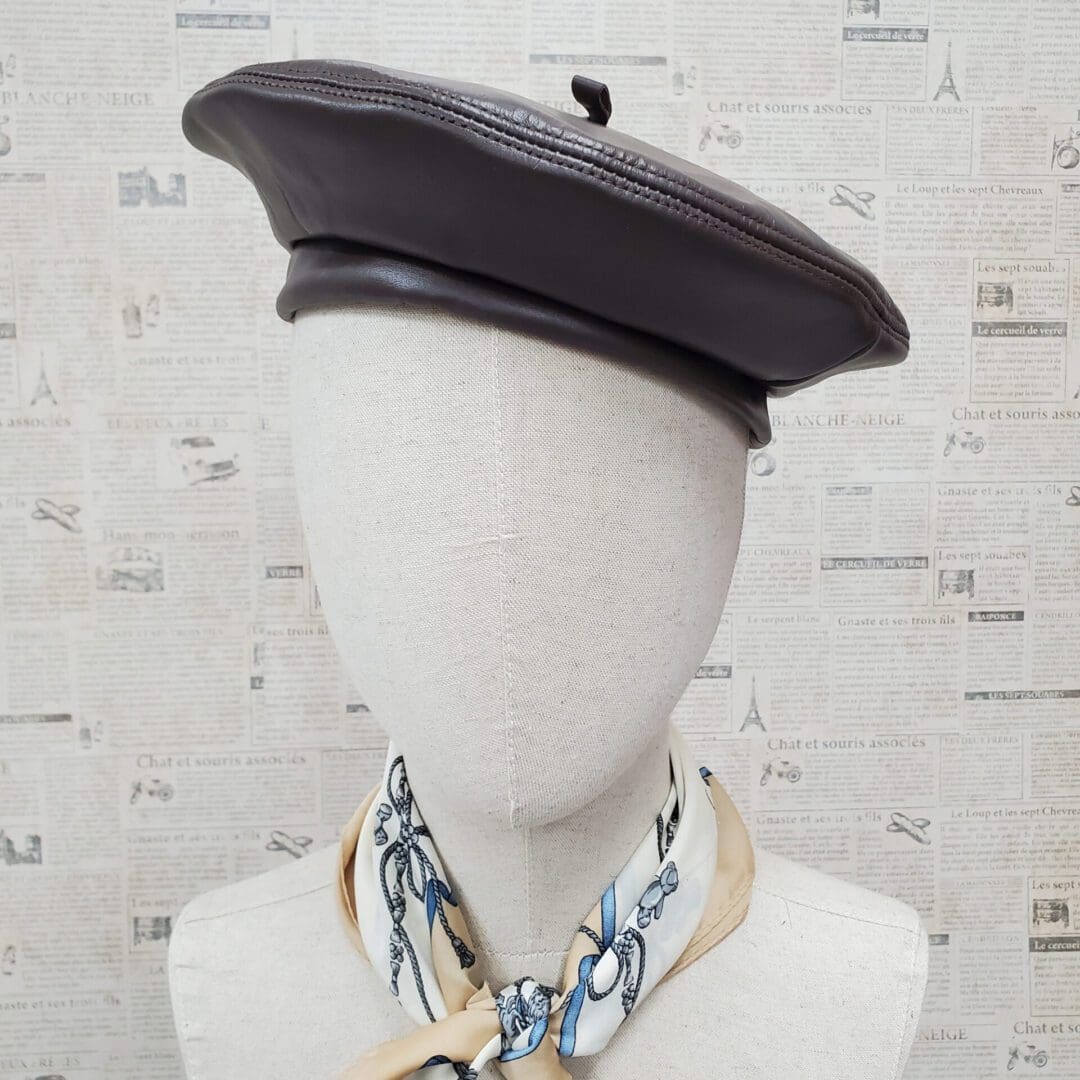 A mannequin wearing a black hat and scarf.