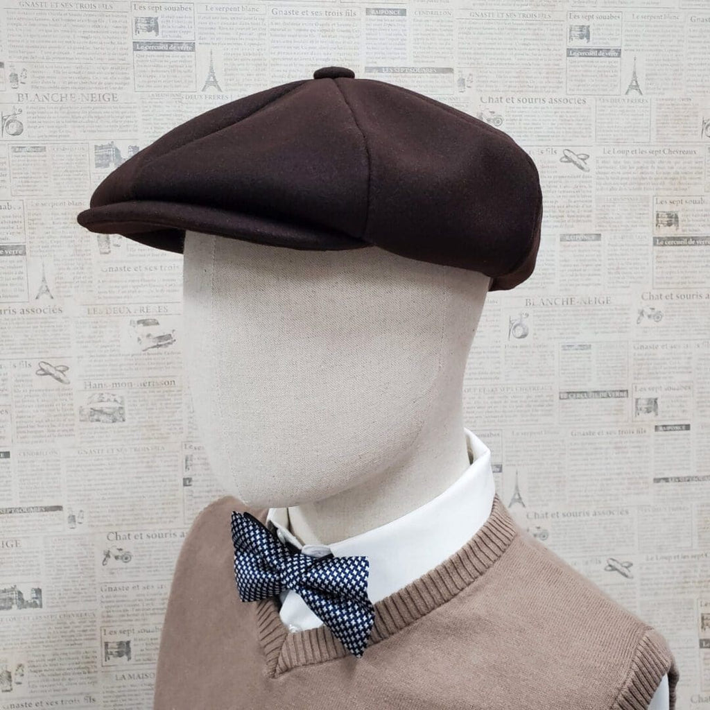 A mannequin wearing a brown hat and bow tie.