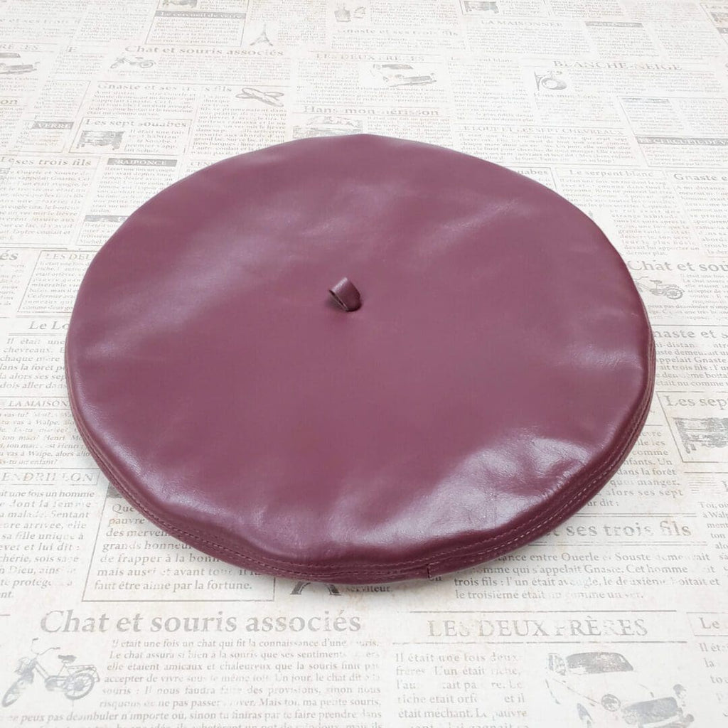A purple leather hat on top of a table.