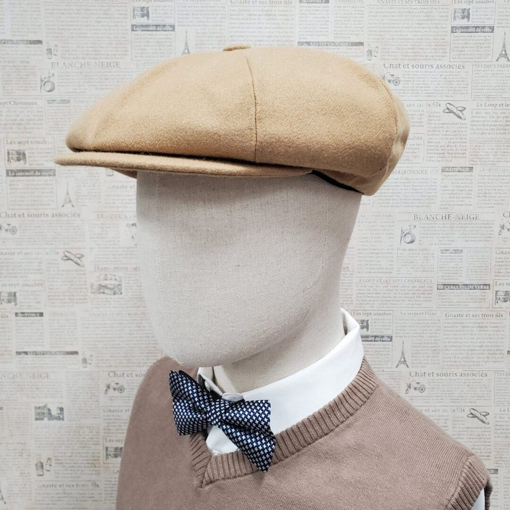 A mannequin wearing a tan hat and bow tie.