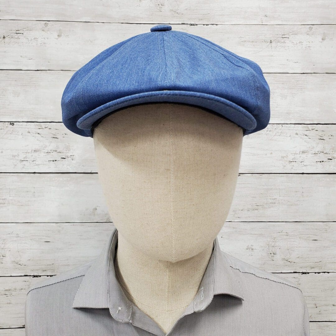 A mannequin wearing a blue hat and striped shirt.