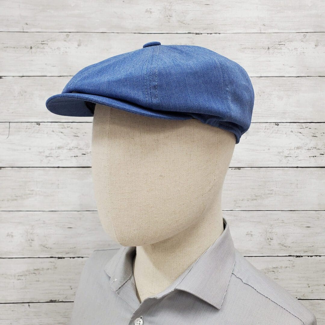 A man wearing a blue hat and gray shirt.