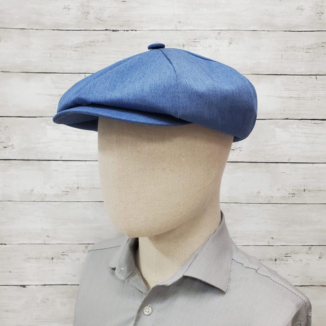 A man wearing a blue hat and gray shirt.