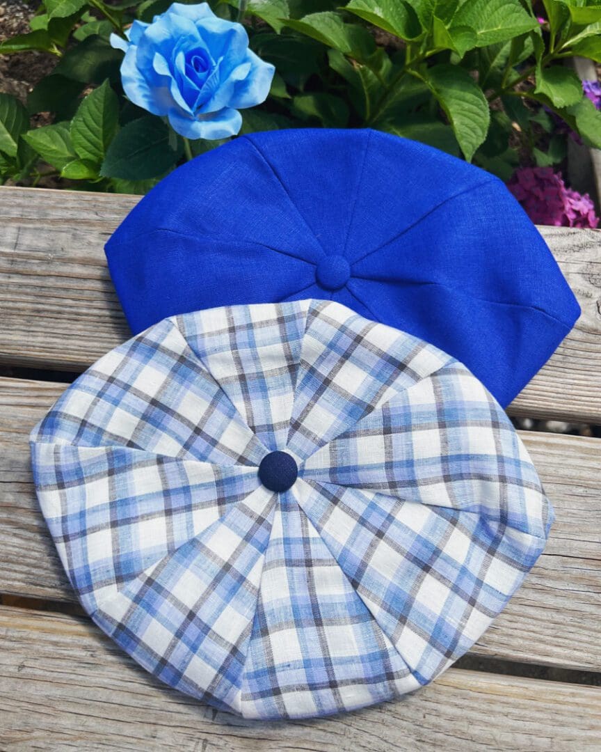 Two hats sitting on top of a wooden table.