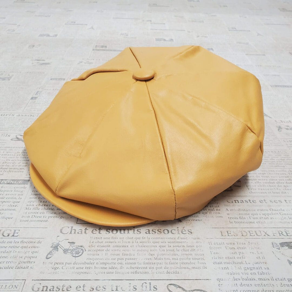 A yellow hat sitting on top of a newspaper.