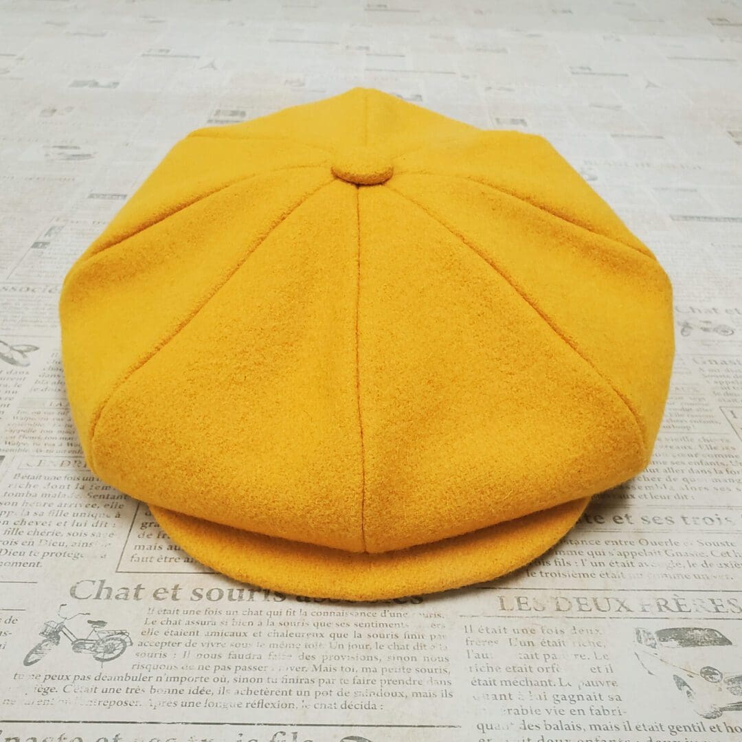 A yellow hat is on top of the newspaper.
