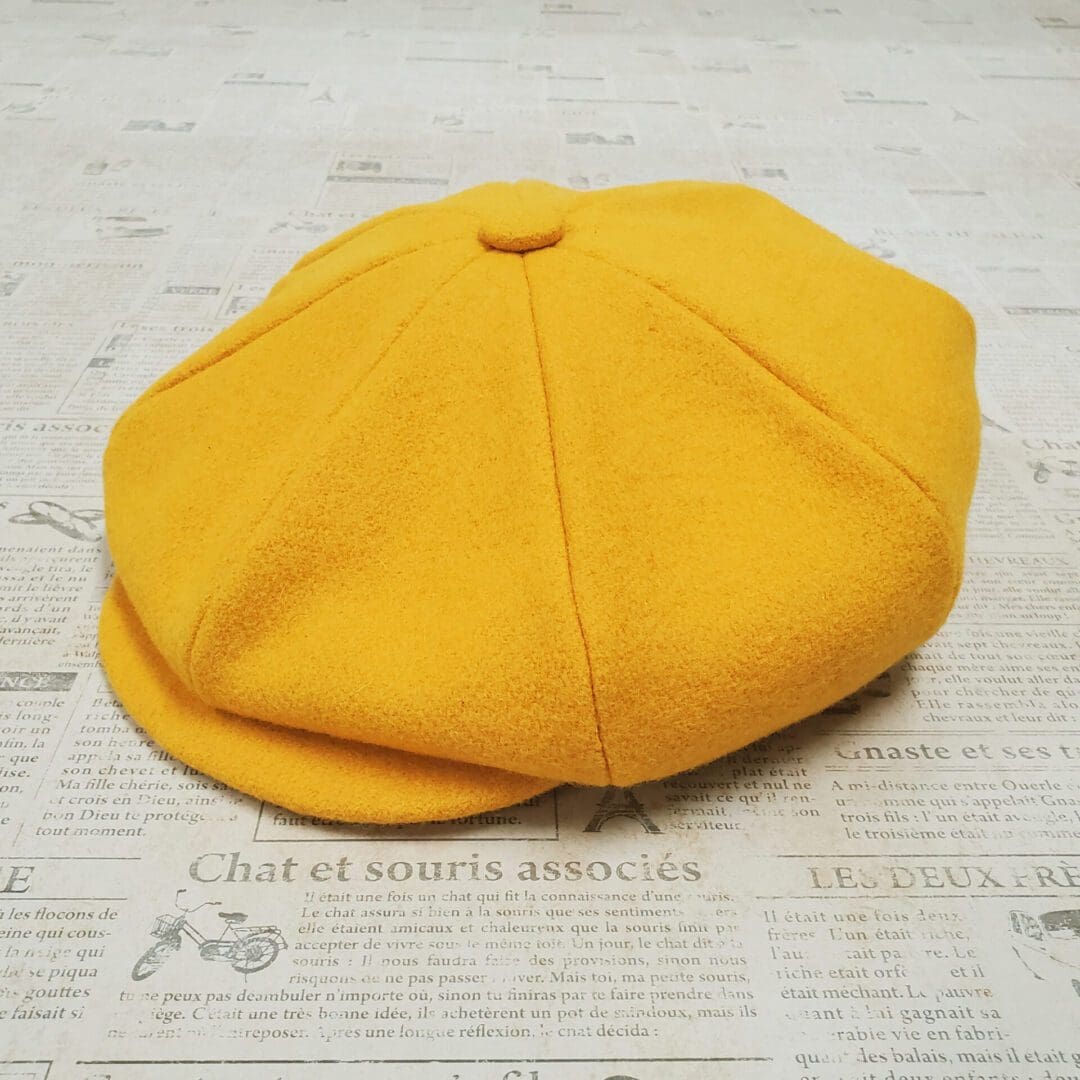 A yellow hat is sitting on top of the floor.