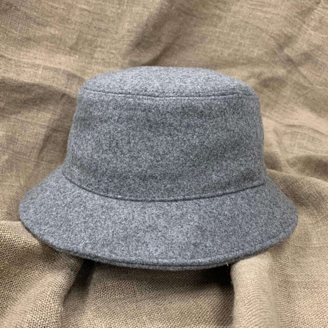 A gray hat is on top of the brown cloth.