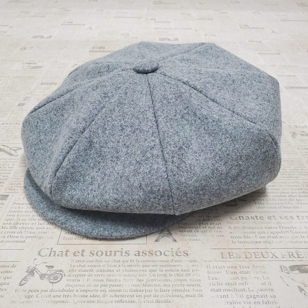 A gray hat is laying on the floor