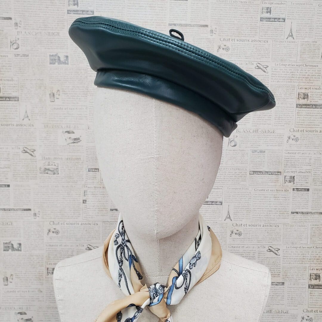 A mannequin wearing a green hat and scarf.