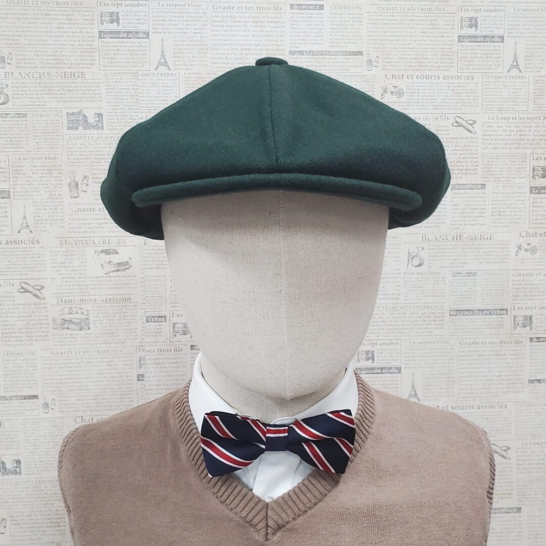 A mannequin wearing a bow tie and green hat.