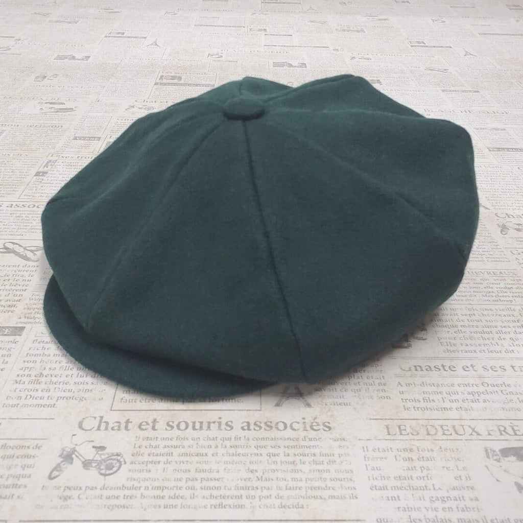 A green hat is on top of the newspaper.