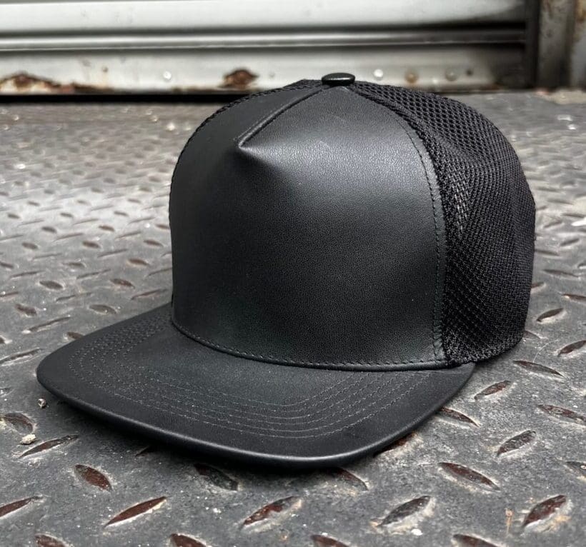 A black hat sitting on top of a metal floor.