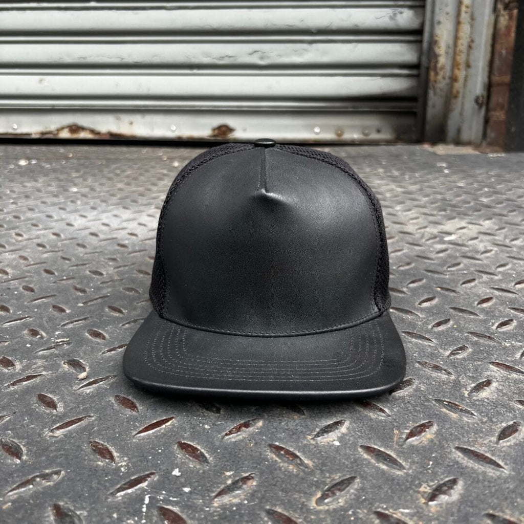 A black hat sitting on the ground in front of a building.