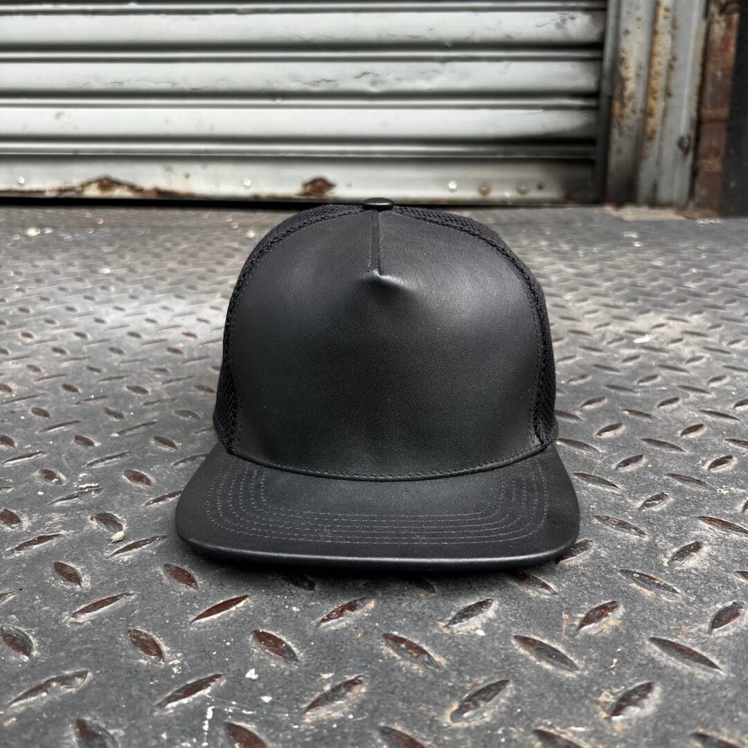A black hat sitting on the ground in front of a building.