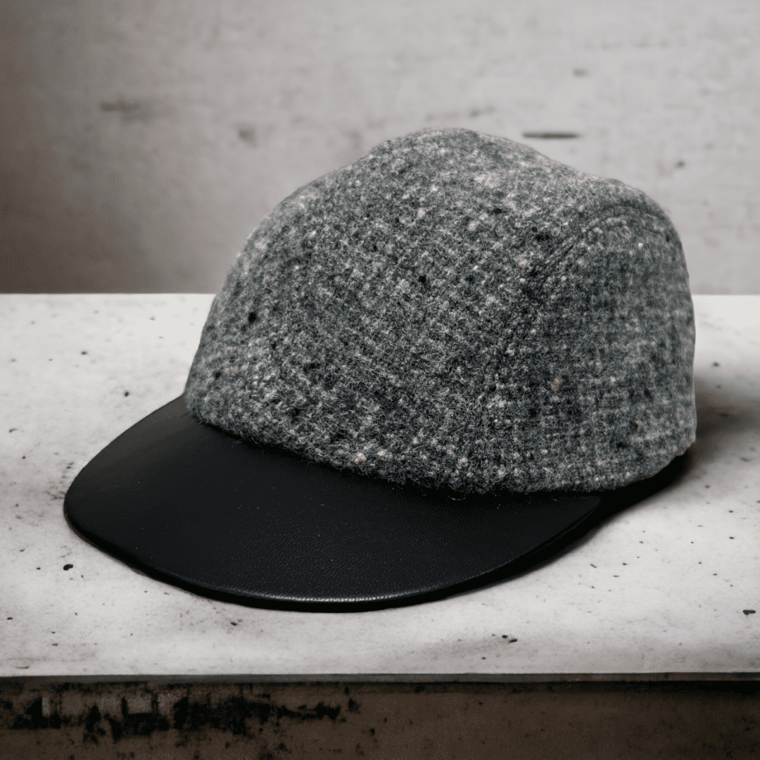 A hat is sitting on the ledge of a bench.