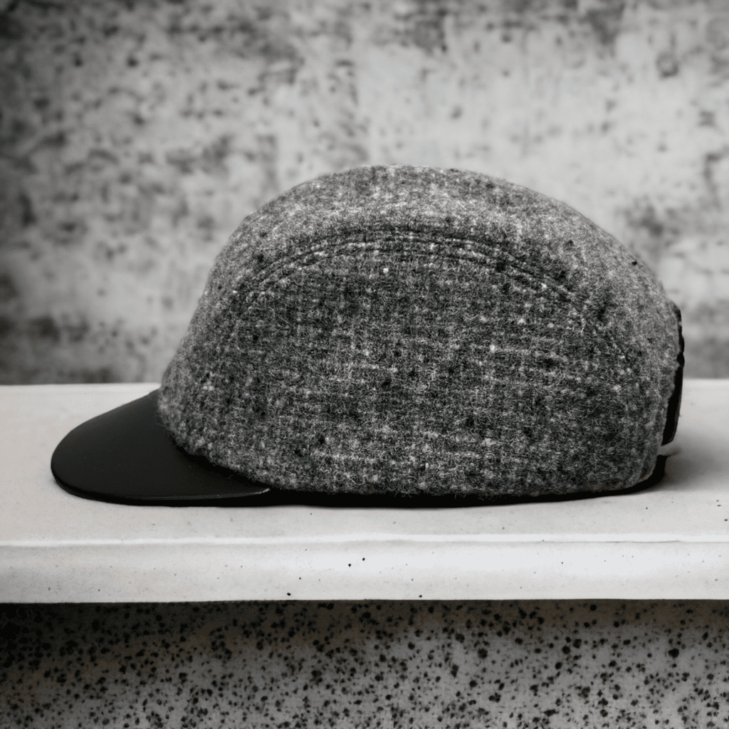 A hat is sitting on the shelf in front of a wall.