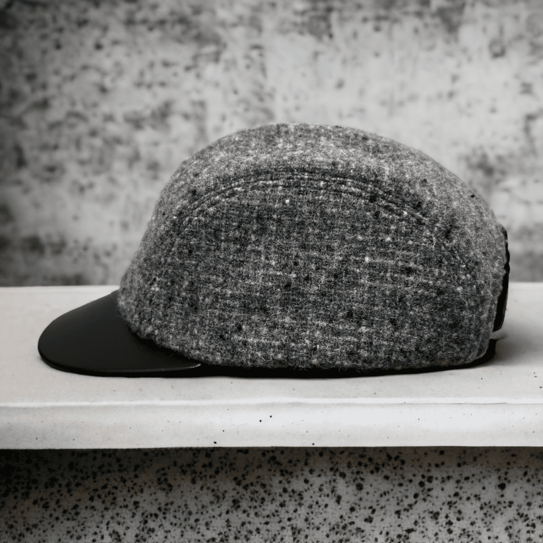 A hat is sitting on the shelf in front of a wall.