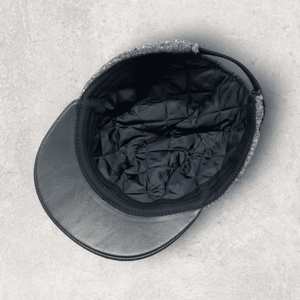 A black hat and cap sitting on top of the ground.