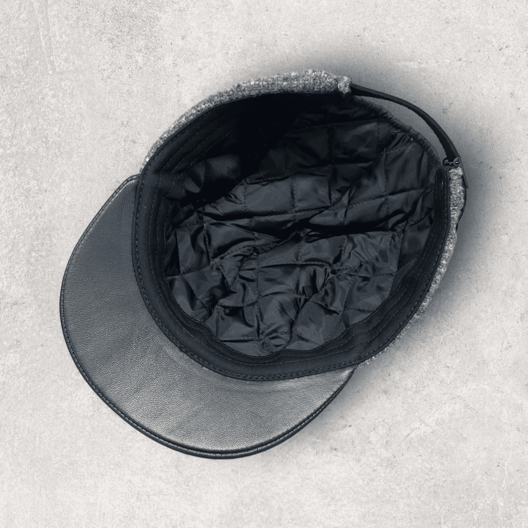 A black hat and cap sitting on top of the ground.