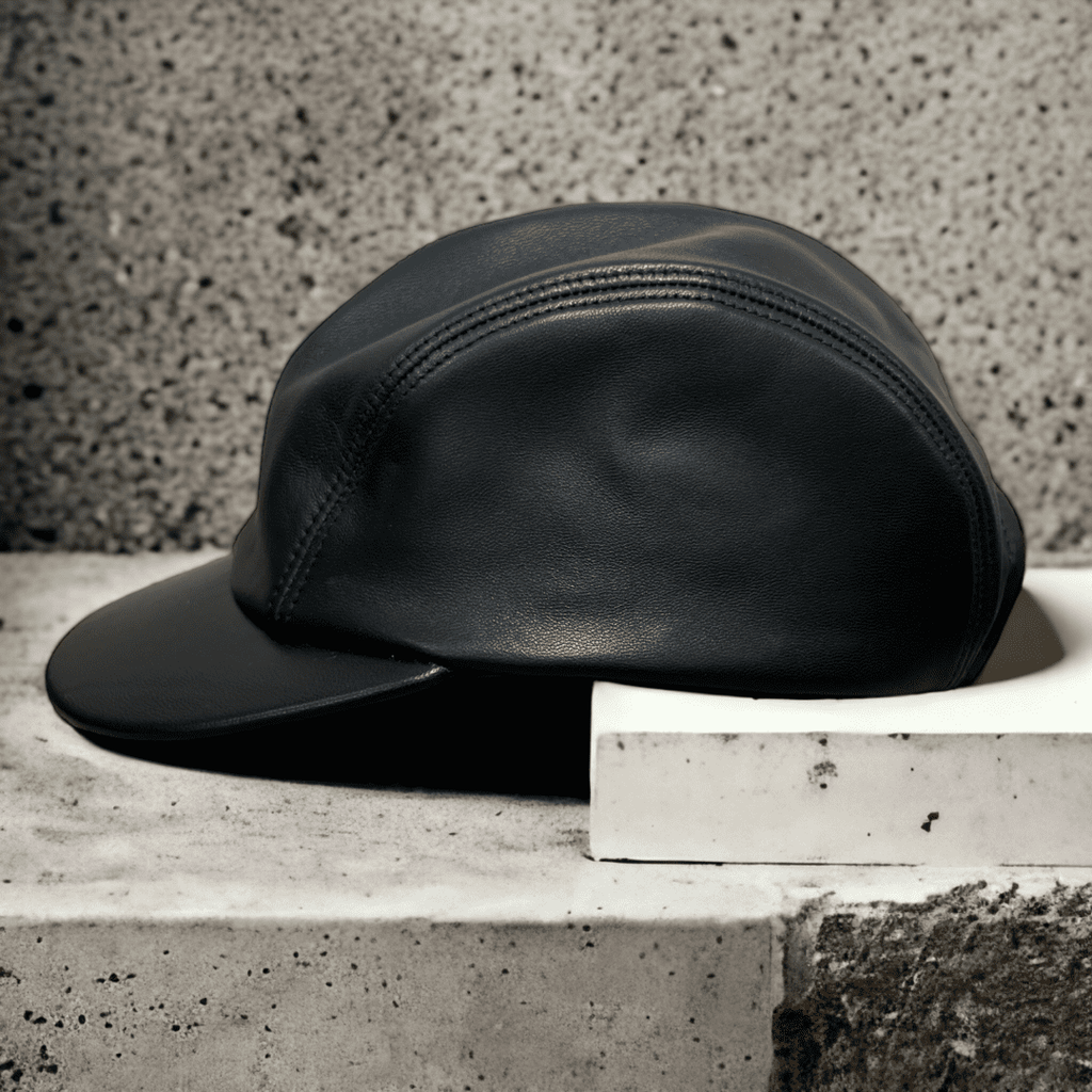 A black leather hat sitting on top of a cement block.
