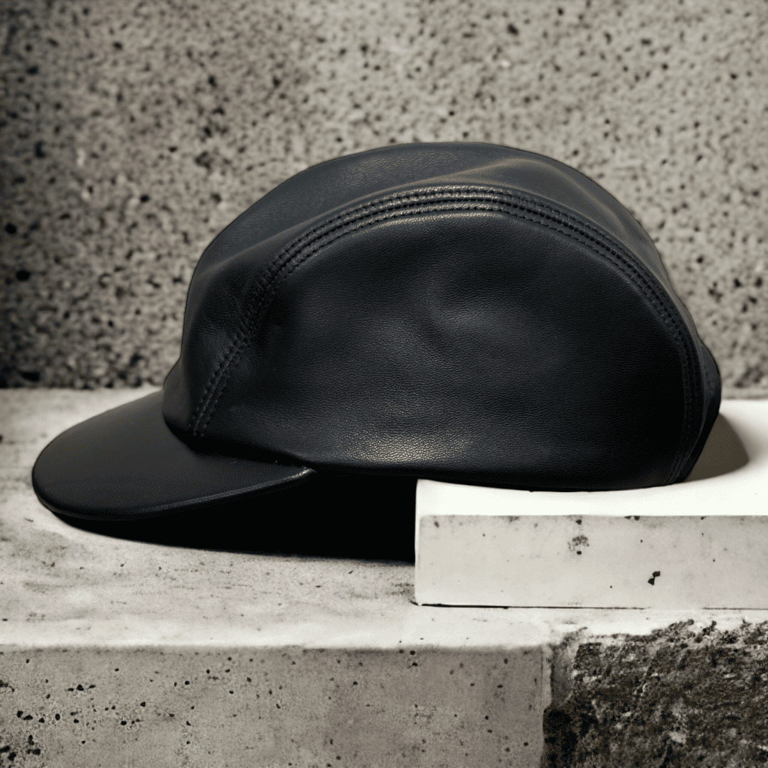 A black leather hat sitting on top of a cement block.
