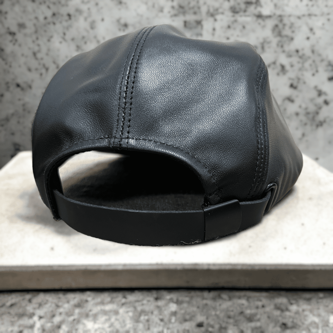 A black leather hat sitting on top of a counter.