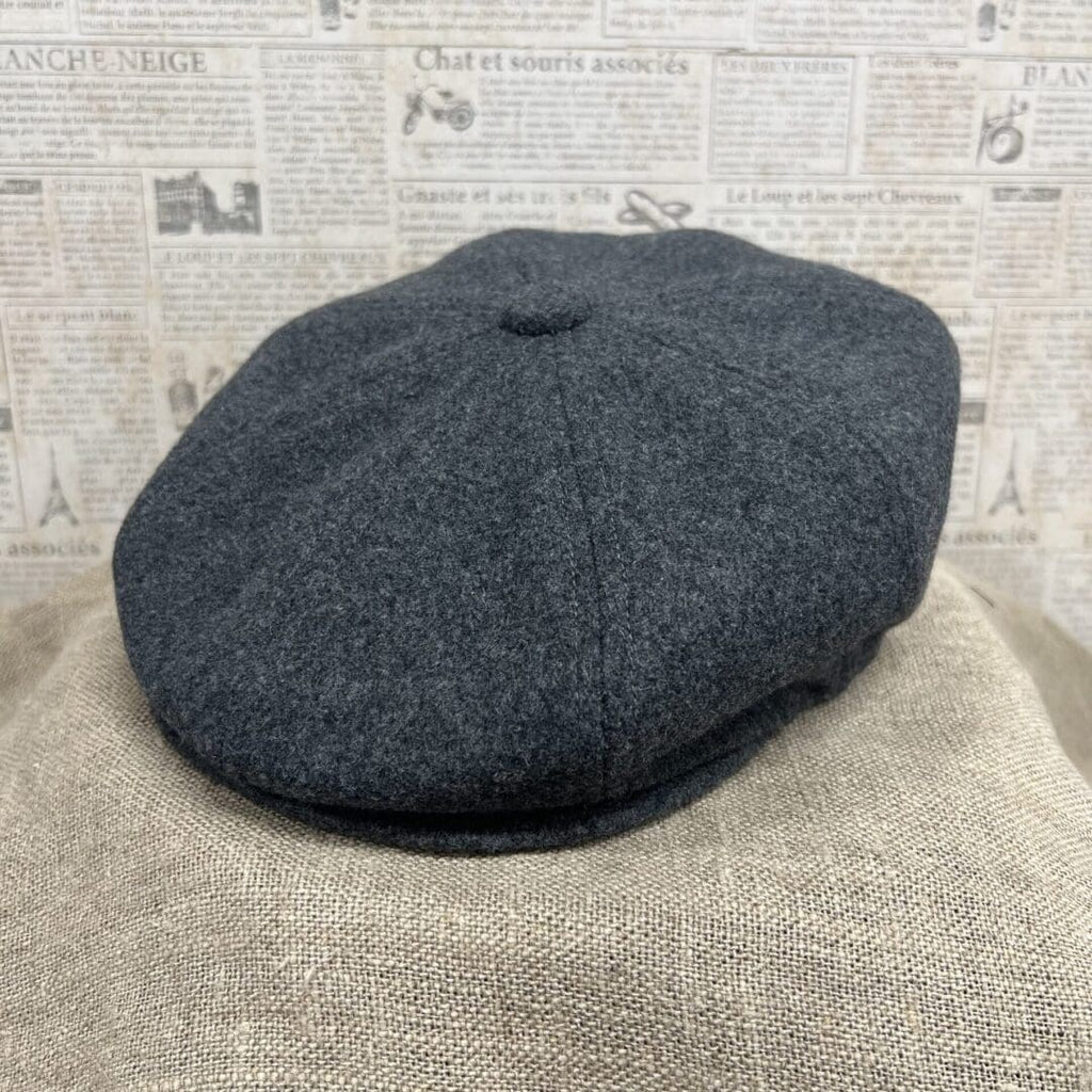 A gray hat sitting on top of a chair.