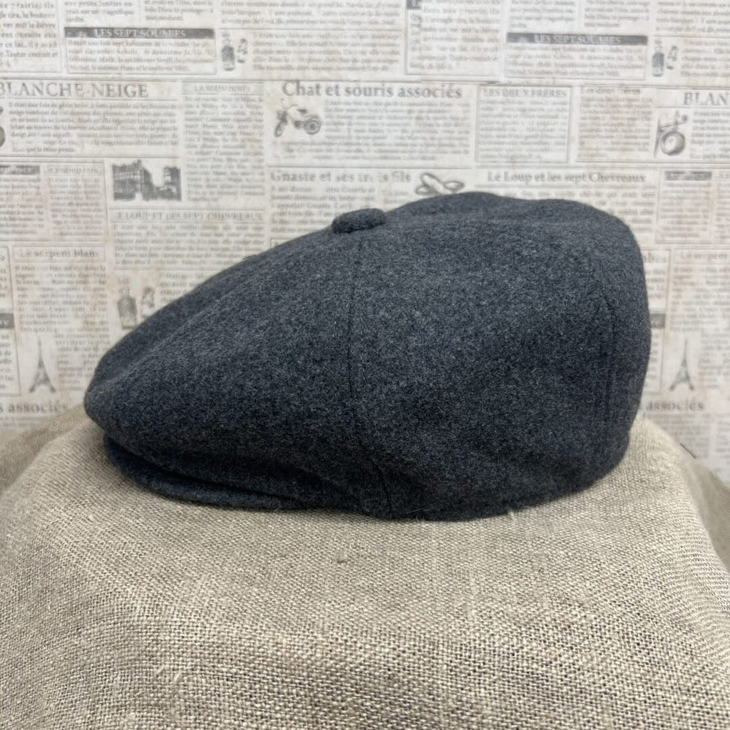 A gray hat sitting on top of a brown chair.