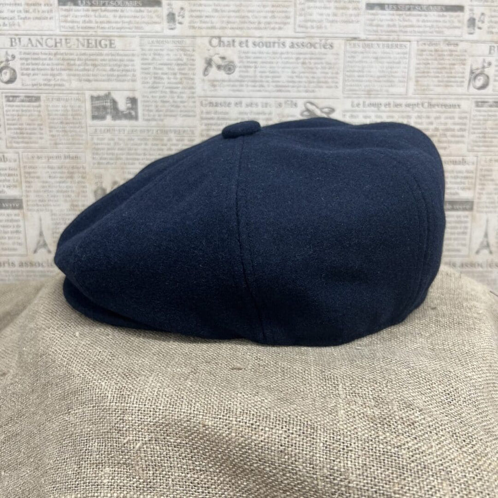 A black hat sitting on top of a brown blanket.