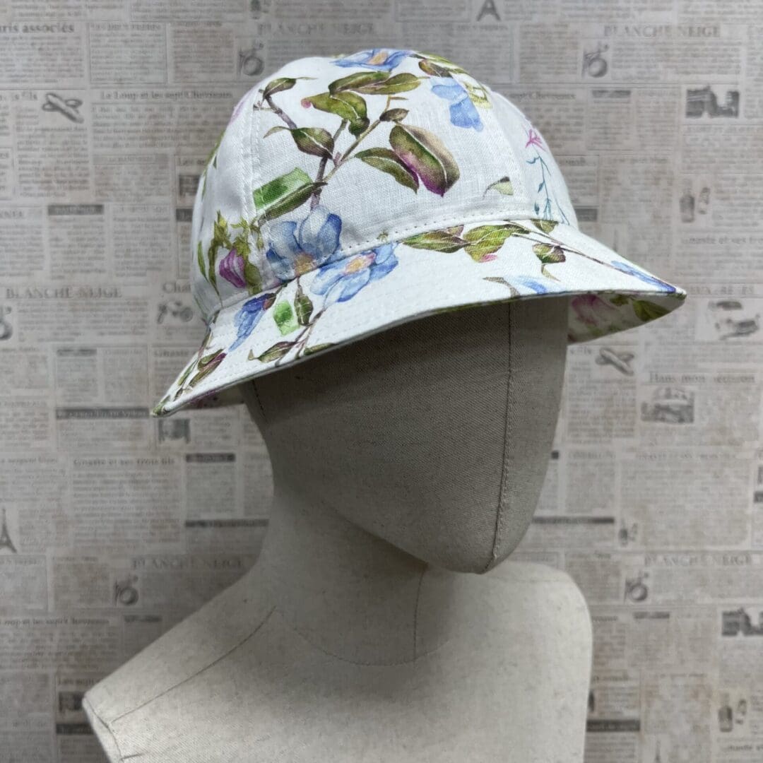 A mannequin wearing a hat with flowers on it.