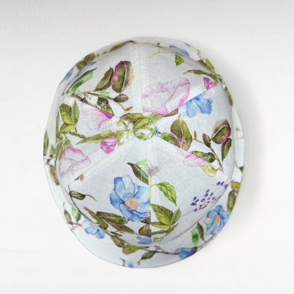 A white hat with blue and pink flowers on it.