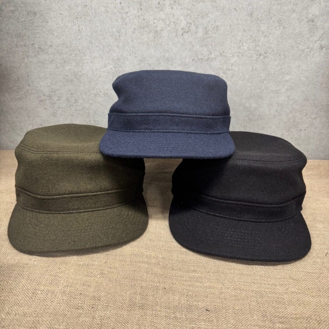 Three military-style caps on display table.