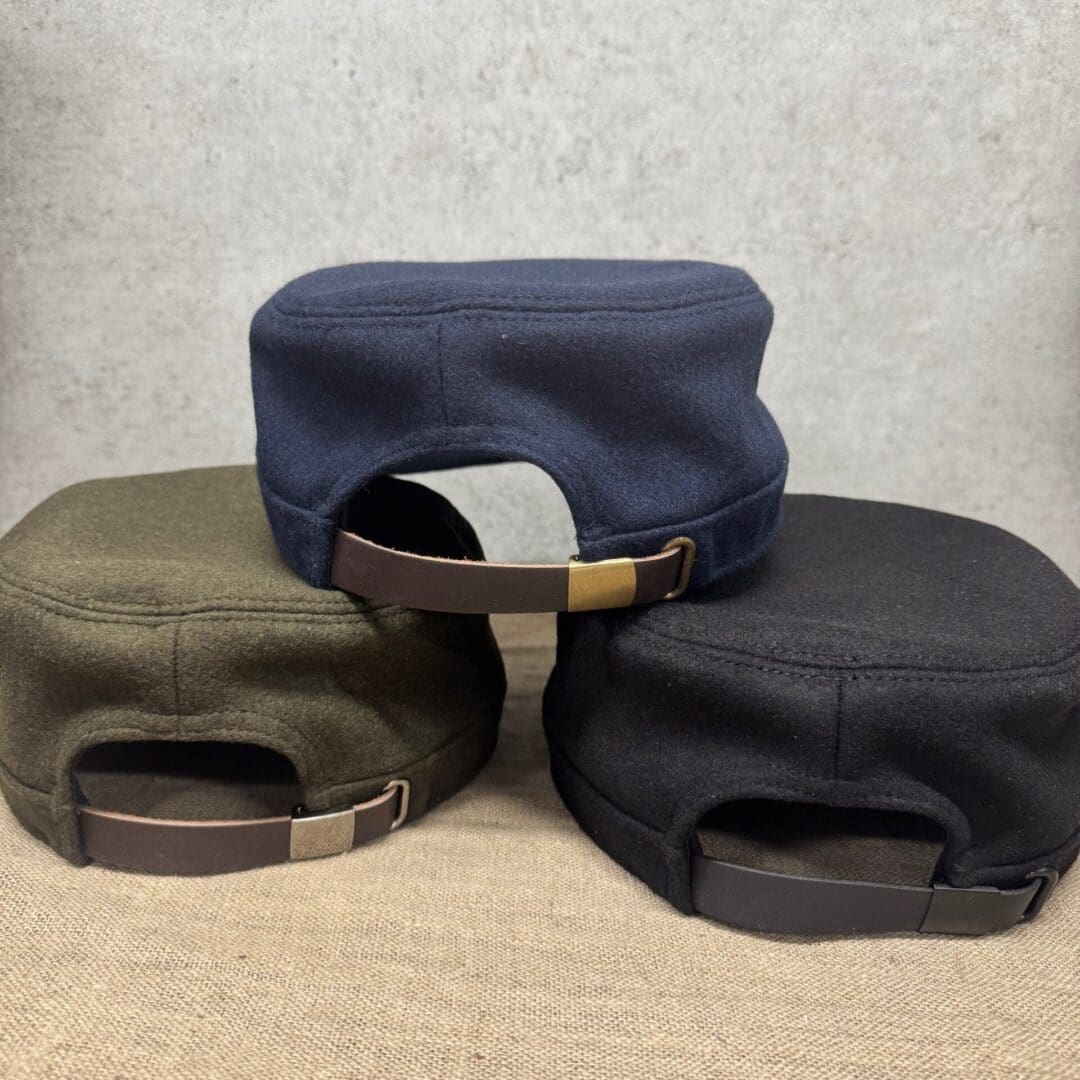 Three caps with adjustable straps displayed.