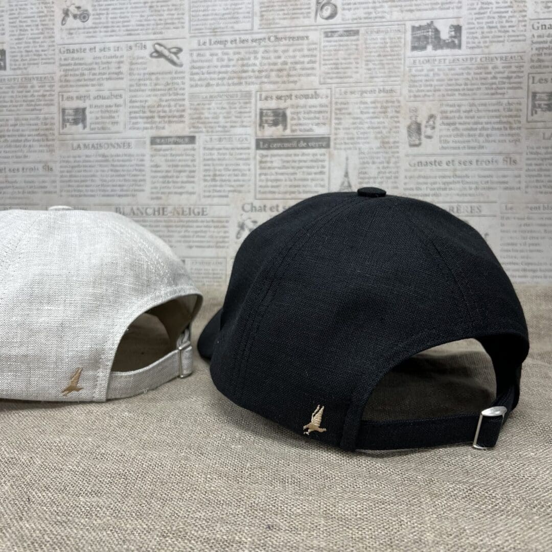 Two hats are sitting on the floor next to a wall.
