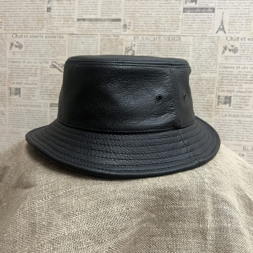 A black hat is on top of a person 's head.