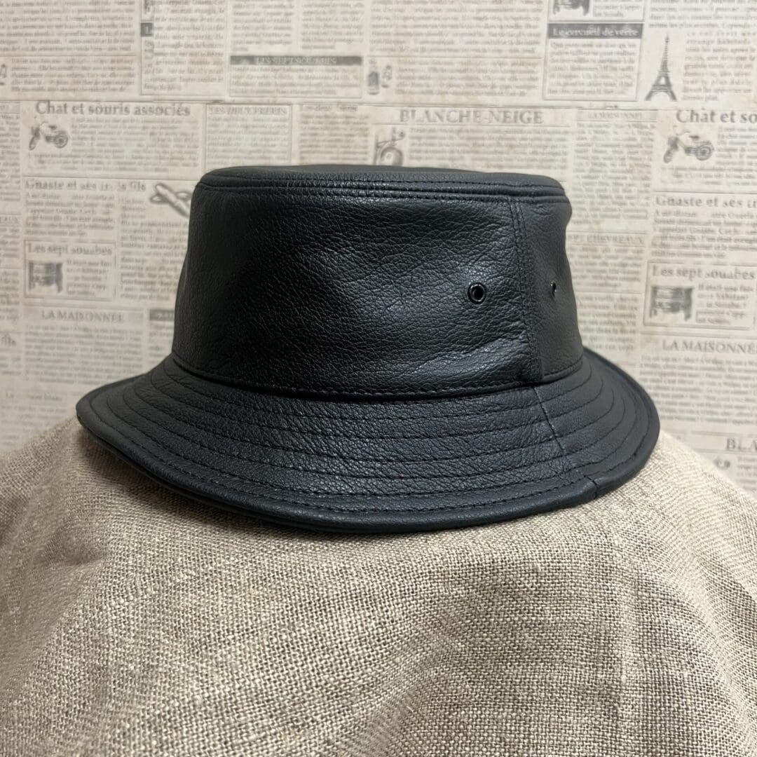 A black hat is on top of a person 's head.