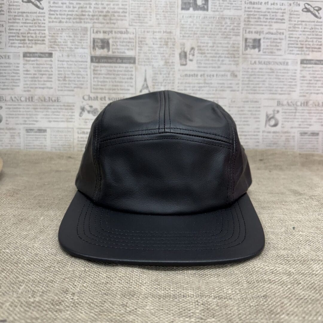 Black leather five-panel camper cap.